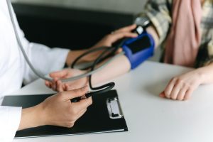 A healthcare professional checking a patient's pulse, representing heart health monitoring.